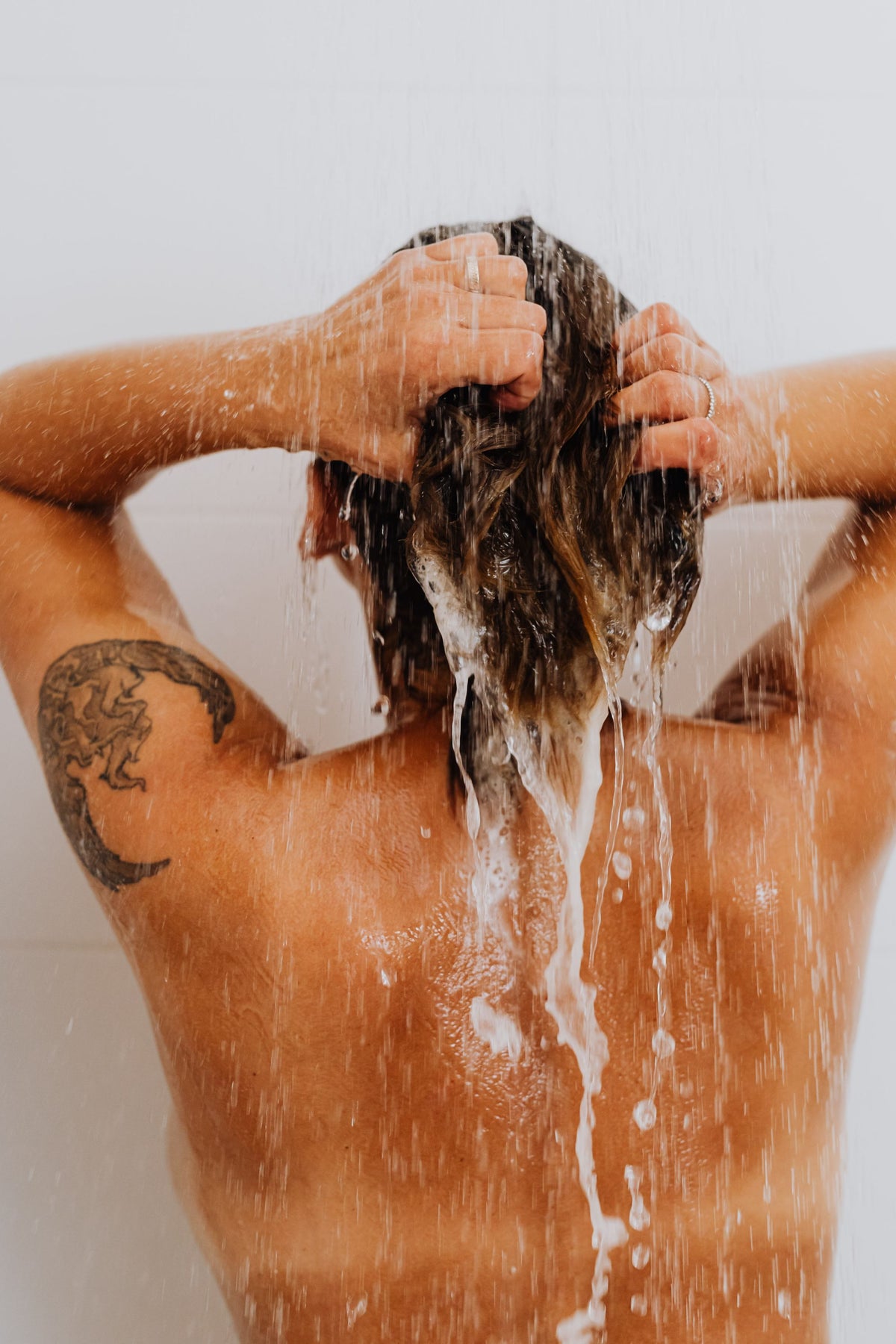 Les gestes d’un shampoing sous l’eau de la douche
