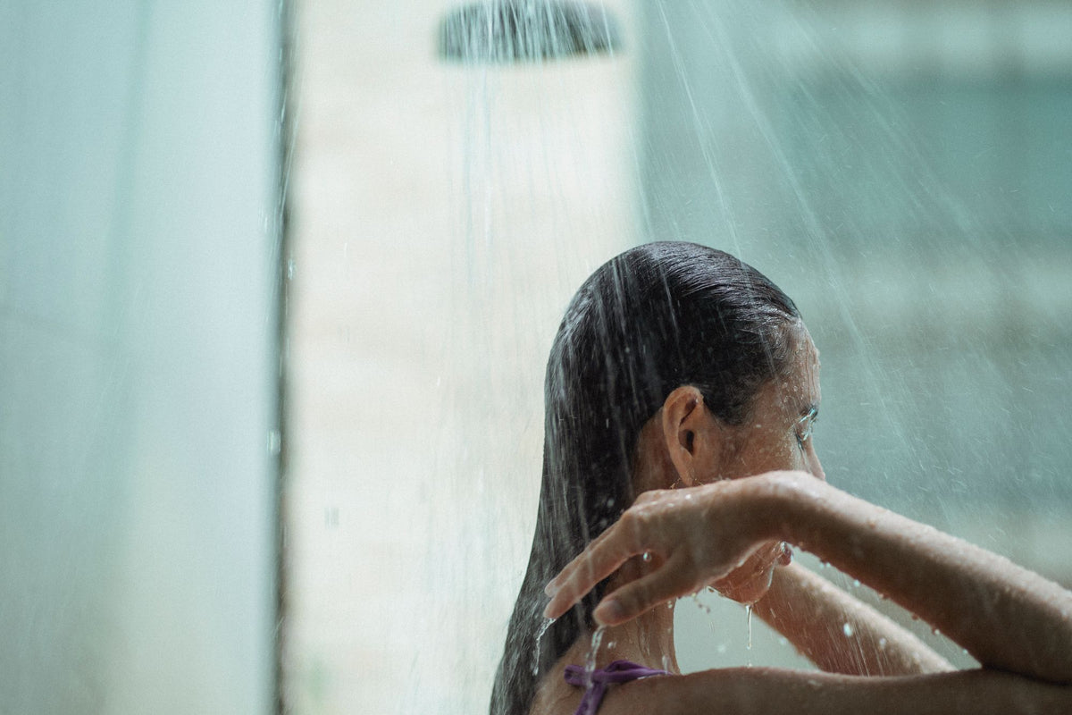 Une femme se rinçant les cheveux sous une douche